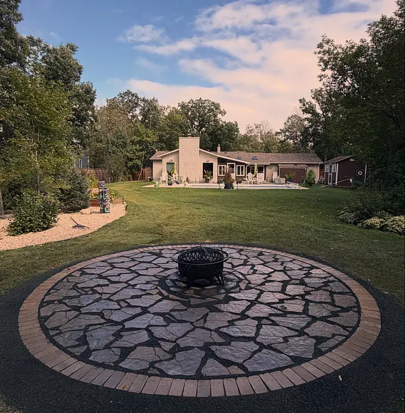 Circular flagstone fire pit patio on a large lawn Circular flagstone fire pit patio on a large lawn